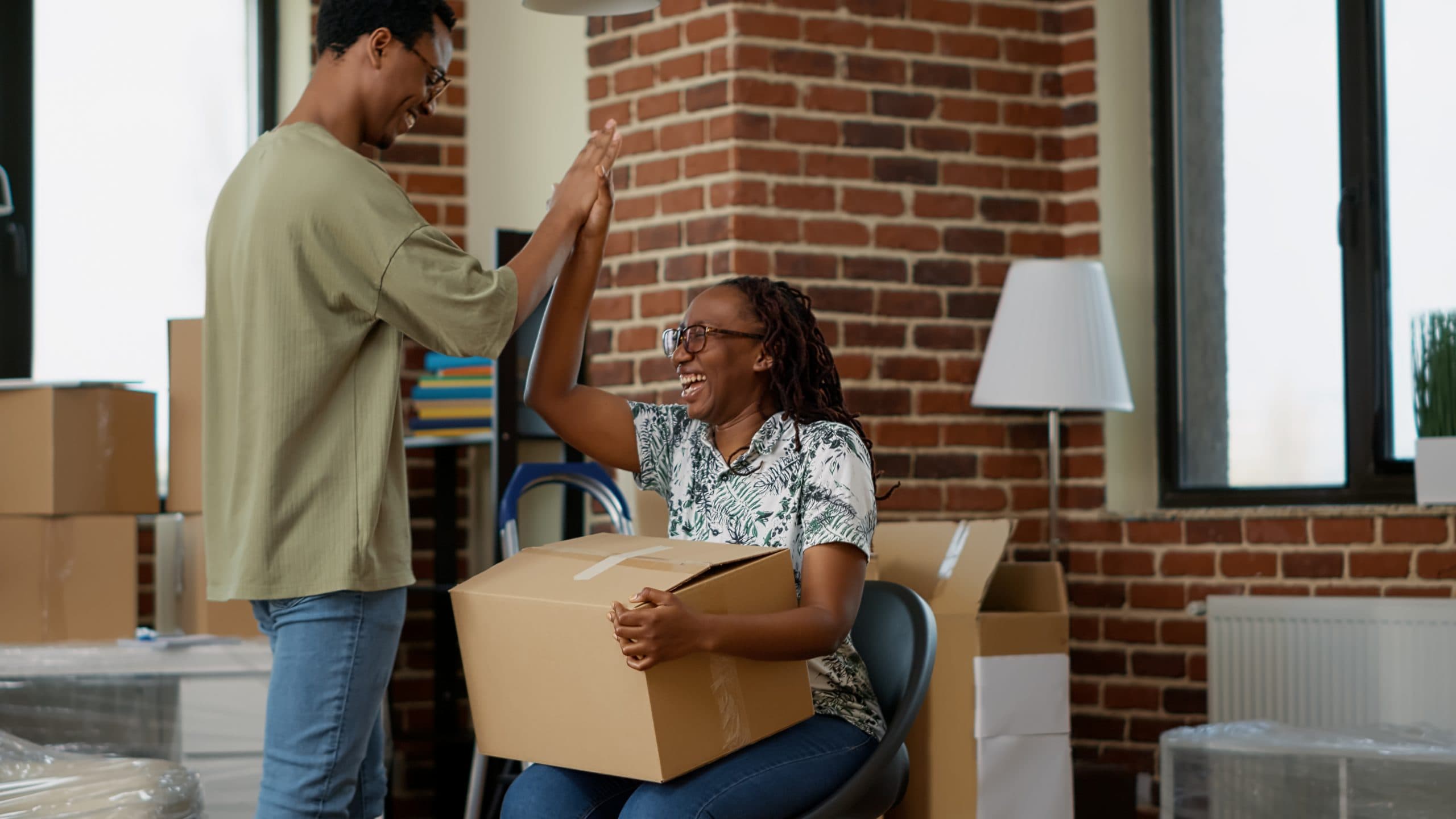 Two people sharing a high five as a boxed order arrives