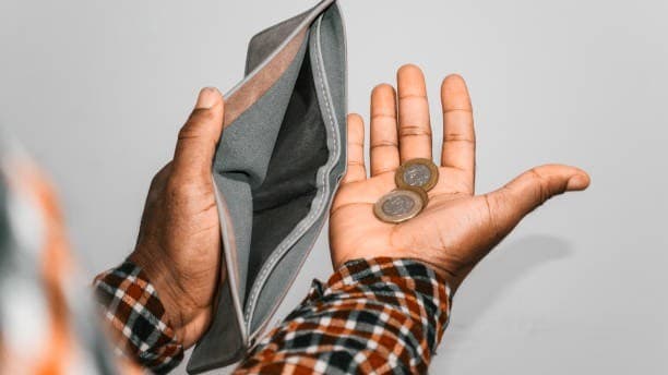 An open wallet holding only a few coins